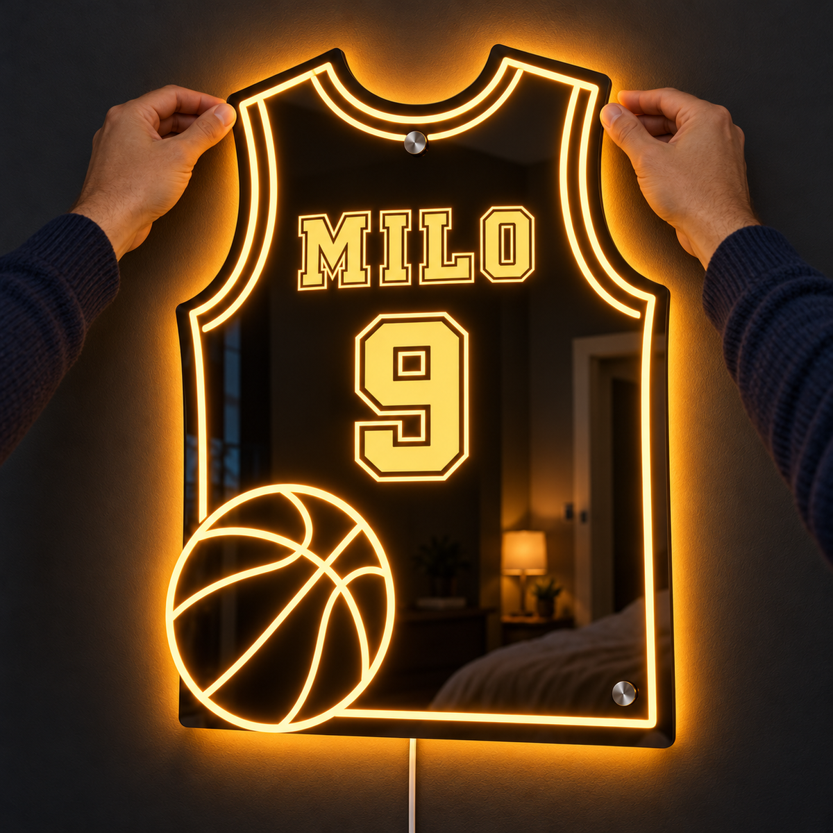 Two hands placing the lit jersey mirror onto the wall, no drilling needed
